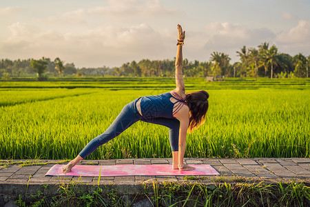 年轻女性在巴厘健康务虚会当天早上在稻田户外做瑜伽健康姿势专注沉思稻田活动花园老师女孩身体背景图片