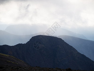 南岗千年瑶寨云层中的山峰 背光下一连串灰色山脉丘陵仙境比丘旅行基岩射线季节地质学墨水太阳背景