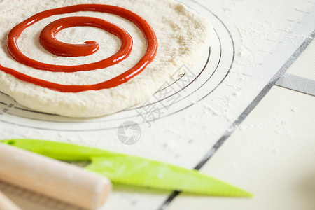 贝里果酱螺旋性地被施用来为甜甜甜甜点卷推出面粉高清图片