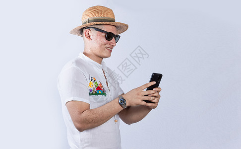 戴沙帽的人用手机打海边帽子 带眼镜的海边人打信息背景图片