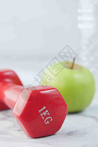 新鲜饮用水 苹果和桌上的粉色哑铃曲线白色艺术背景图片