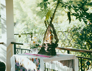 阳台阳台阳台上的青铜佛像雕像背景图片
