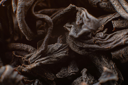 作为背景的黑色散叶茶 干红茶叶的质地 深色背景 极端微距模式 黑叶茶特写宏观饮料茶叶芳香草本植物叶子草本香气树叶背景图片