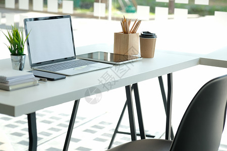 办公桌上的咖啡杯 办公室内用电脑平板纸笔铅笔植物药片咖啡盆栽杯子电话工作键盘手机记事本背景图片