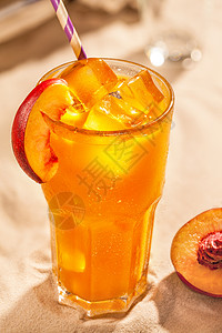 夏季冷饮 蜜桃红酒 在沙底的玻璃中装有冰块高清图片