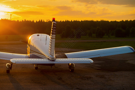 四轮式飞机停在私人机场 看到日落背景有螺旋桨的飞机后视线尾巴运输旅行天气吹笛者自由航班航空轮子齿轮背景图片