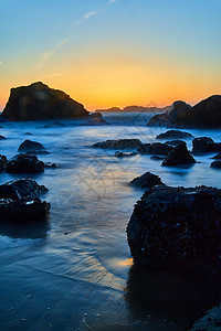 加州金麻石加州金时海滩上岩石周围的平滑波浪背景