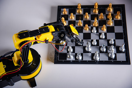 特写黄色机器人臂 在棋盘上下棋电脑科学典当战略技术手臂实验室机器优胜者研究背景图片