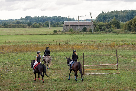 年轻女孩在马场比赛前穿上马匹 小男孩骑马参加赛事哺乳动物宠物训练良种场地牧场骑士运动员骑师孩子背景图片