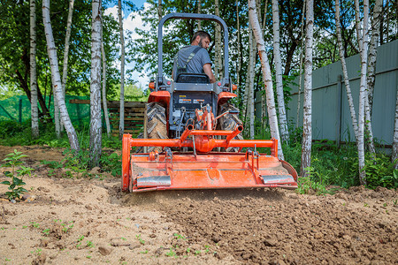 微耕机使用小型拖拉机的农民为草坪解开土壤 土地耕种 地面平整农业石头工作栽培舵柄耕作耕地机器场地生育力背景