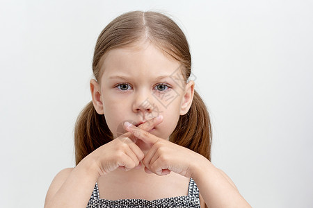 构音障碍严重儿童在嘴上交叉手指背景