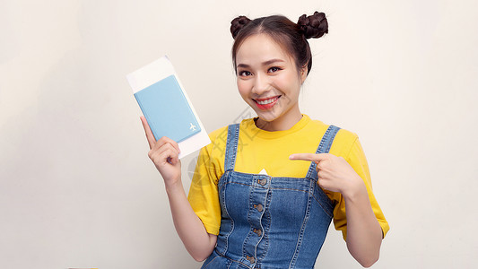 年青美丽的亚洲旅游女青年 在度假时持护照 用手指和极好的符号指着护照女士快乐展示假期喜悦情感微笑游客韩国人高清图片素材