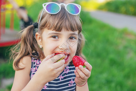 好吃你就多吃点孩子夏天会吃草莓 有选择的专注点微笑乐趣浆果童年小吃饮食甜点营养快乐水果背景