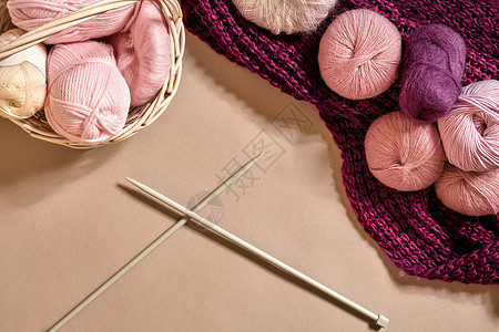 紫色毛球线光效毛线球 柳条盘中的彩色纱线球 用于在米色背景上编织的纱线 针织作为一种针线活 织针和多色纱线看起来很明亮衣服艺术褐线针织袜黄纱创背景
