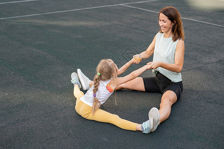 母亲和女儿去户外运动 白人妇女和小女孩正在体育场健身女士婴儿女性体操灵活性妈妈闲暇童年跑步孩子们背景图片