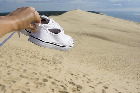 欧洲最大沙丘皮拉特沙丘背景下的白色旅行鞋高清图片