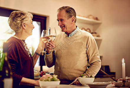 一对年长的夫妇在厨房里聊天和喝酒 站在一起喝着葡萄酒 你就会觉得好过一点背景图片