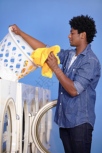 一个好看篮子他负责洗衣 一个英俊的男人在洗衣店洗衣服 是个帅哥背景