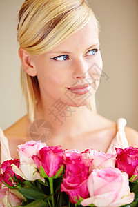 一个秘密崇拜者的礼物 一名年轻女子拿着一束粉红玫瑰被割伤的镜头背景图片