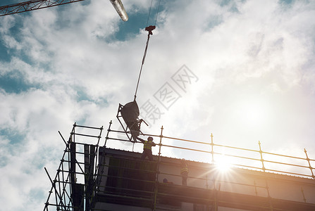 装备越强大 完成度就越高 一名男子在建筑工地用起重机吊起重型机械的镜头背景