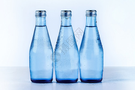 工作室拍摄了三瓶玻璃水瓶的镜头背景图片