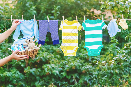 婴儿洗衣洗婴儿衣物 在新鲜空气中干枯床单 有选择的焦点乐趣衣服花园家务洗衣生活女孩母亲母性衣绳背景