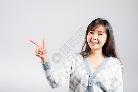 欢笑的快乐女人指着空间游客商业头发管理人员女孩毛衣微笑女性手指工作室背景图片
