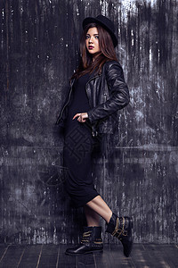 穿着深色衣服的美女模特女孩女性帽子热情黑发冒充夹克皮革化妆品黑色背景图片