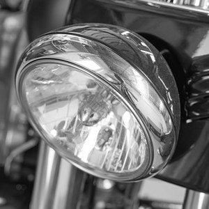 摩托车前灯的特写 带黑白滤镜的摩托车灯 银色现代经典镀铬机动车上的一个灯泡 自行车上清洁 光滑的铬维护背景图片