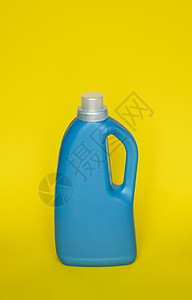 蓝塑料瓶以黄色背景为代表 用于洗涤的装饰品或液体粉末 具有复制空间的能力 标识应用布局等背景图片