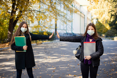 两名戴着医用防护口罩的大学生相距 1 5 米背景图片
