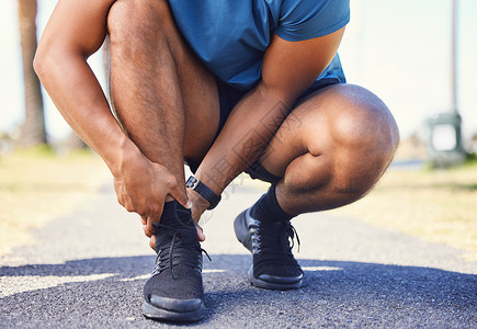 非必要不外出活跃的混血男子在外出跑步时脚踝疼痛的特写镜头 不知名的运动员因脚踝扭伤或运动损伤而感到不适 锻炼伴随着疼痛的风险背景