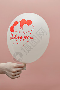 情人节卡片上写有文字的地方 在孩子手上挂着爱情字的气球 在粉红色背景上问候语明信片青少年幸福邀请函礼物背景图片