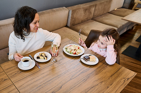 中东小女孩幸福慈爱的母亲和她可爱的甜美女儿的头像 — 可爱的小女孩在自助餐厅一起吃早餐背景