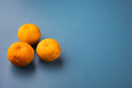 新鲜有机橙子水果 以蓝色纹质的夏季底色为蓝色 并有文本复制空间背景图片