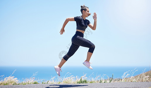 混天绫年轻的混种女子在空中跳跃时 在其日常锻炼中跑出户外的年青混合种族跑步成人训练运动街道身体女性太阳女士调子背景