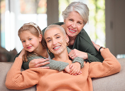 互相扶持 一个成熟的女人在家里的沙发上与她的女儿和孙女建立联系的肖像背景