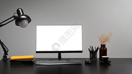 前面有白屏 书本 铅笔架和黑桌上的灯具的电脑背景图片