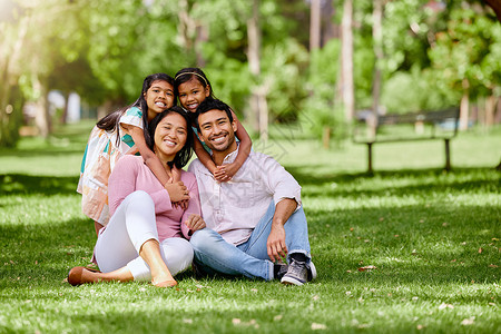 家庭煮夫幸福的亚洲家庭在公园里的画像 可爱的小女孩在公园外结合并拥抱他们的父母 全长丈夫和妻子坐着和女儿一起享受空闲时间黑发女儿们女孩夫背景