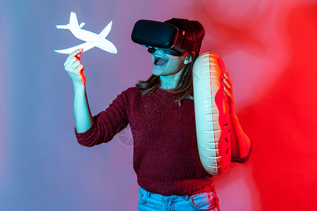 年轻情感女性的肖像 在色彩多彩的荧幕背景眼镜模拟器娱乐女孩创新耳机技术旅行旅游航空公司背景图片