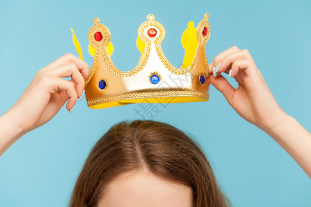 妇女将头戴金冠 颁奖仪式概念 特权地位等挂在王冠上高清图片