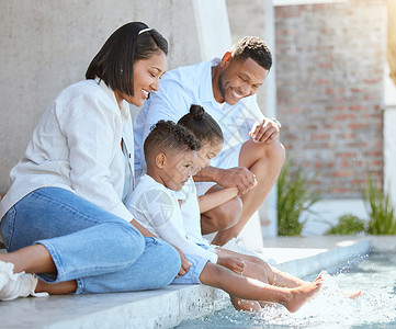 天气好甜美 一个美丽的家庭在外边放松 在游泳池里浸泡脚下背景图片