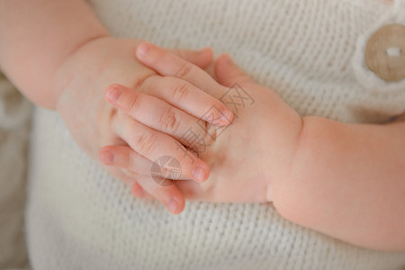 婴儿脐带怀着美丽姿势的新生儿之手背景