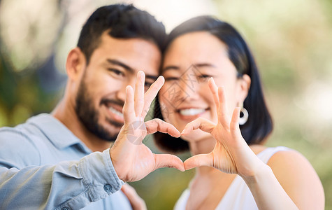 如果你这样做如果你的心高兴 我的也是 被一对快乐的年轻夫妇拍到 在花园里做一个心脏形状的手势背景