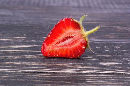 半草莓宏观红色食物种子浆果植物叶子蔬菜水果木头背景图片
