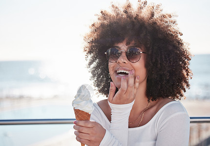 蛋卷头发型夏天是所有甜点中沉浸的夏天 一个年轻女子享受户外冰淇淋锥背景