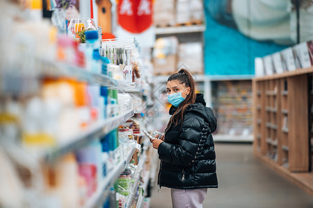 在病毒流行期间 戴面罩买东西的女人女士成人口罩全世界店铺购物封锁面具防护疾病背景图片