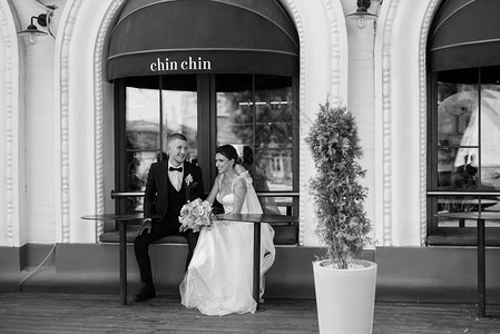 咖啡馆附近的新娘和新郎女孩咖啡店女士婚礼城市棕色街道幸福家庭白色背景图片
