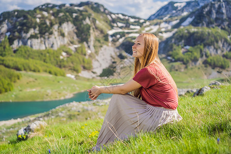 黑山美丽的杜米托尔国家公园杜米托尔山湖景中的女游客 拥有湖泊冰川和反射山旅游女士风景石头男人蓝色全景目的地儿子母亲背景图片