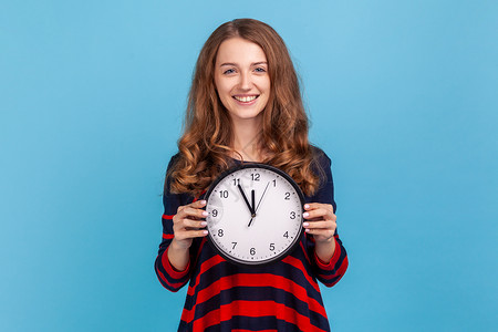 女人拿着时钟 对镜头微笑 表示乐观 有足够的时间 不急背景